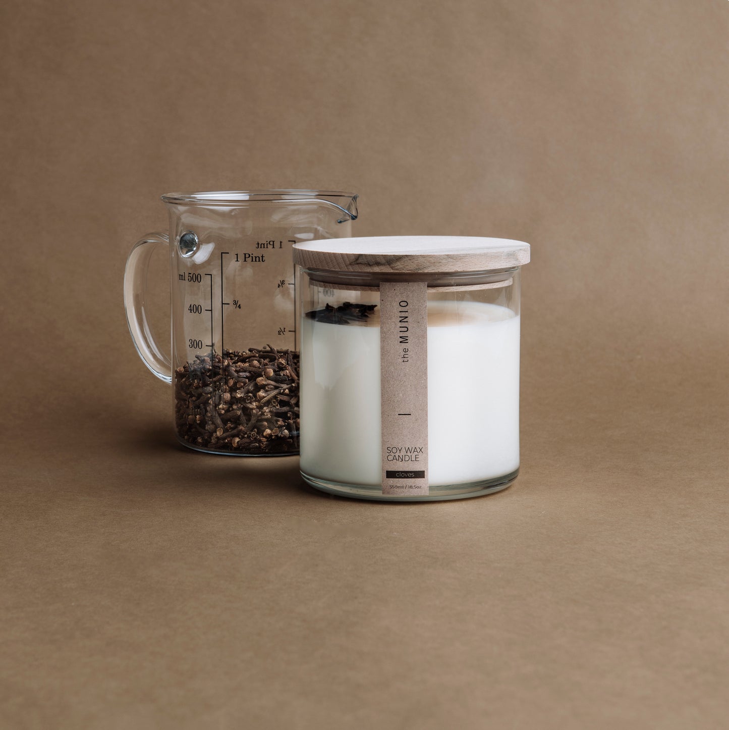 Nelken und Orangenkerze im Glaswindlicht