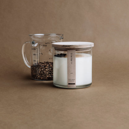 Nelken und Orangenkerze im Glaswindlicht