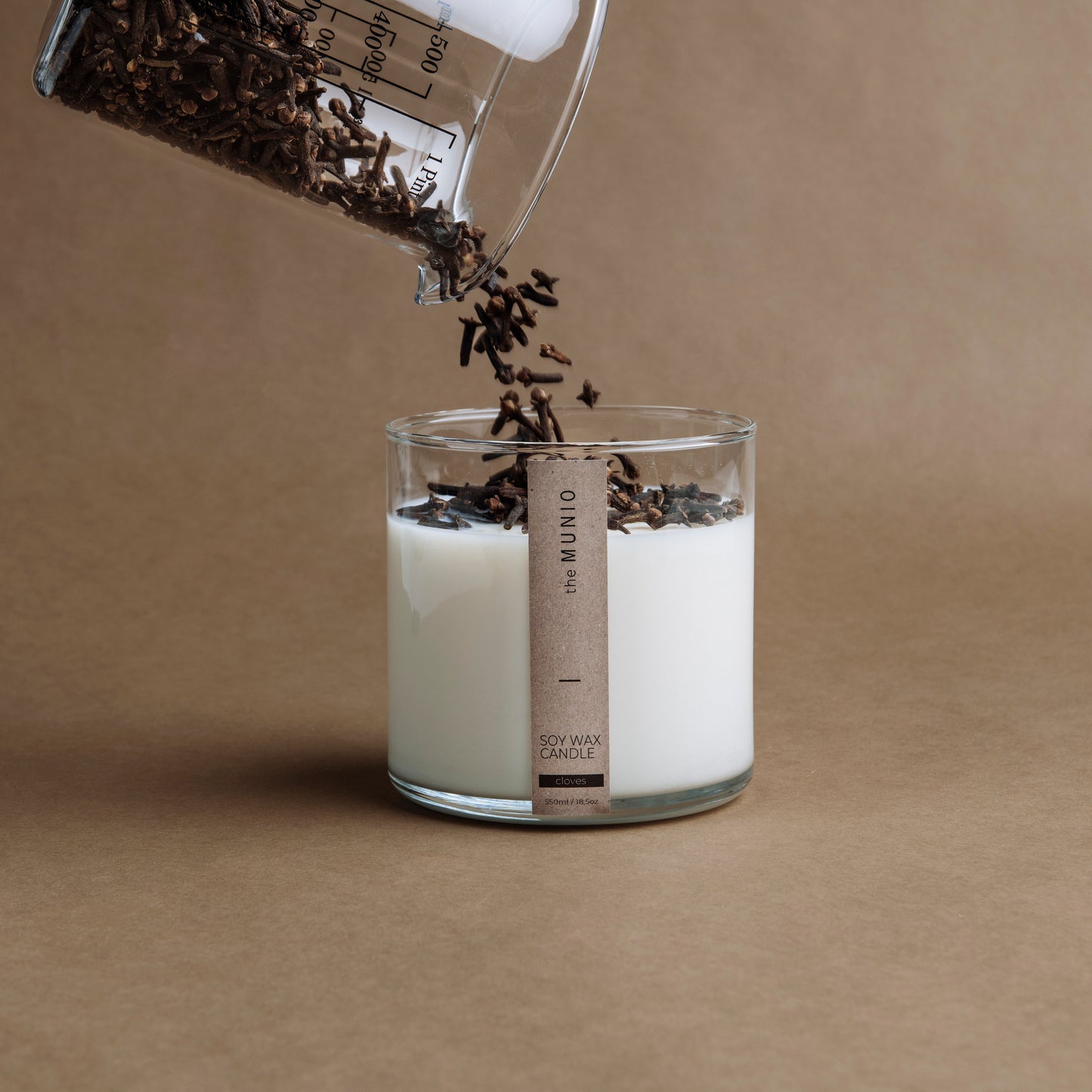 Nelken und Orangenkerze im Glaswindlicht